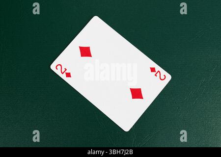 Two of Diamonds Playing Card on Green Table Stock Photo