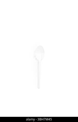 A plain white plastic spoon, ideal for single-use at parties, picnics, or take-out meals isolated on white background creating a minimalist and clean Stock Photo