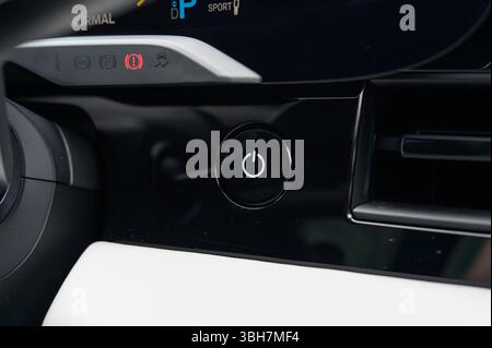 A car dashboard with a power button on it. The button is black and white. The dashboard is black and white as well Stock Photo