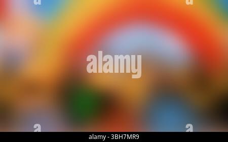 A lively, blurred abstract rainbow background showcases dynamic swirls of orange, blue, and golden hues, creating an energetic and artistic visual tex Stock Photo