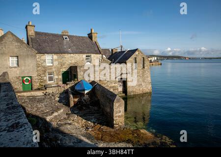 Da Lodberries in Lerwick glow in the summer morning sun – historic waterfront homes on Shetland’s shoreline. Stock Photo