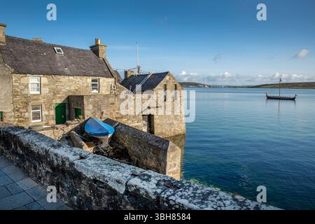 Da Lodberries in Lerwick glow in the summer morning sun – historic waterfront homes on Shetland’s shoreline. Stock Photo