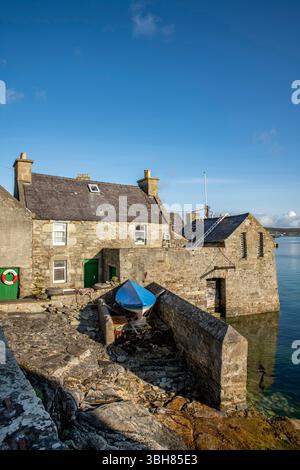 Da Lodberries in Lerwick glow in the summer morning sun – historic waterfront homes on Shetland’s shoreline. Stock Photo