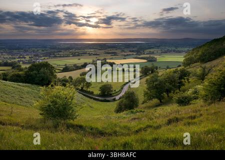 View at sunset over the Severn Vale to the Severn Estuary from Coaley Peak viewing point in the Cotswolds near Nympsfield, Gloucestershire. Stock Photo