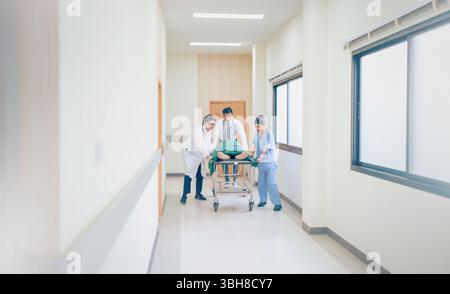 Doctor team and nurse staff carrying stretcher with patient from the accident ambulance running to the surgery room in hospital Stock Photo