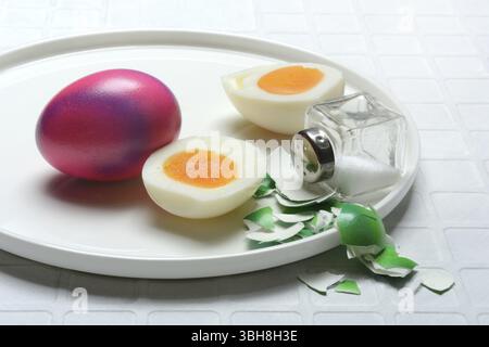 Easter eggs and salt shaker on plate, partially peeled Stock Photo