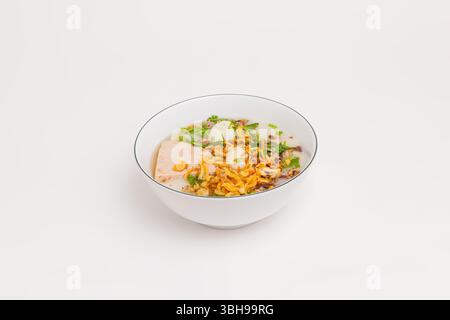 A bowl of Banh Duc, a traditional Vietnamese steamed rice cake with minced pork, fried shallots, fresh herbs, and a slice of pork loaf. Vietnamese foo Stock Photo