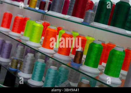 Colored embroidery spools with thread. Sewing industry Stock Photo