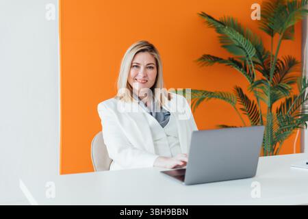 Woman in business suit working with online laptop in office Stock Photo