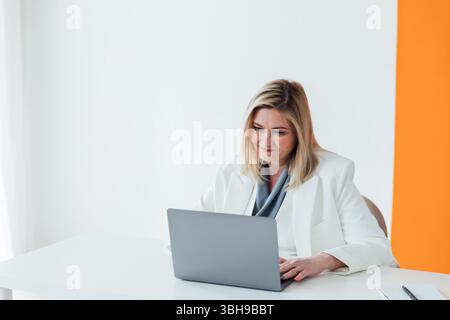 Woman in business suit working with online laptop in office Stock Photo