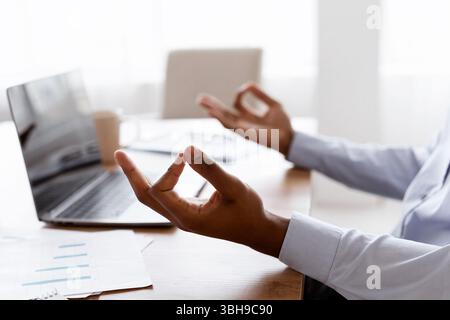 Cropped of office worker sitting at workdesk, meditating Stock Photo