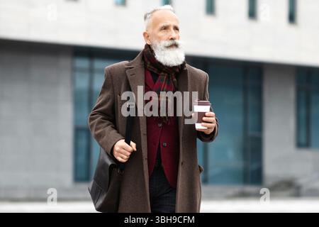 Successful aged businessman going from business meeting, drinking coffee Stock Photo