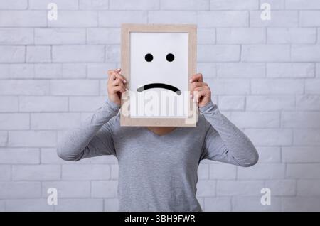Frame with a sad face, mental health concept, negative mindset ...