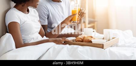 Happy black couple having breakfast in bed at home Stock Photo