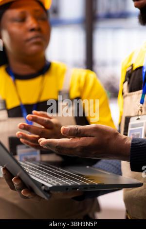 Two automated factory technicians analyze automation data, ensuring efficiency in industrial plant. Their work supports industry 4.0 innovation in smart manufacturing and autonomous systems. Stock Photo