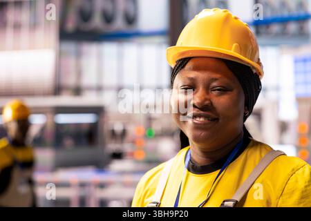 Professional engineer in smart factory optimizing industrial automation production. Portrait of black female technician in facility using industry 4.0 system software for efficient manufacturing. Stock Photo