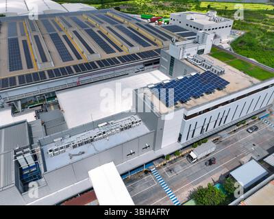 Solar-powered warehouse facility with freight trucks at loading docks. Eco-friendly logistics and efficient cargo transportation. Solar panels Stock Photo