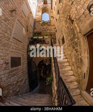 Split, Croatia - September 8th 2023: Tourists explore the historic Diocletian's Palace, navigating its narrow stone stairways and archways. Stock Photo