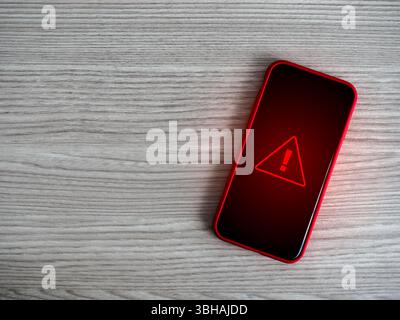 Warning alert screen. Red triangle, system hacked urgent sign, malware, attention danger symbol, system error, scam notification showing on mobile pho Stock Photo