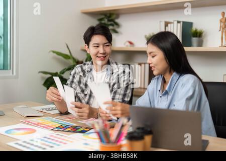UX and UI Design Interaction. Young creatives analyzing color samples and discussing layout options in a bright office. Stock Photo