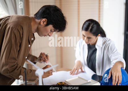 Innovative ESG Solutions in Architecture. Young architects collaborating on sustainable designs. Stock Photo