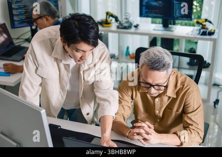 Group of asian senior in a collaborative software development analyzing  flowcharts  during a bootcamp training Stock Photo