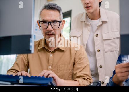 Asian Instructor Teaching Senior in Software Programming and Training Collaboration Stock Photo