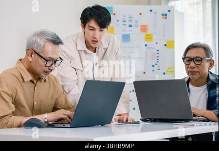 Asian Instructor Teaching Senior in Software Programming and Training Collaboration Stock Photo