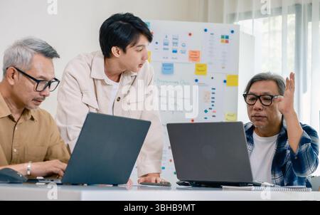 Asian senior bootcamp team asking and  learning programming with software training and whiteboard collaboration Stock Photo