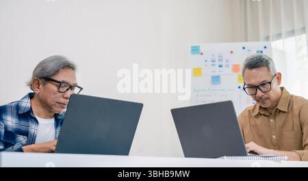 Senior male participating in a computer programming bootcamp, improving skills and learning coding and develope collaborating in brainstorming and cod Stock Photo