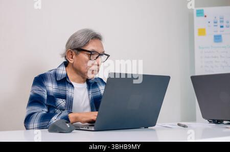 Senior male participating in a computer programming bootcamp, improving skills and learning coding and develope collaborating in brainstorming and cod Stock Photo
