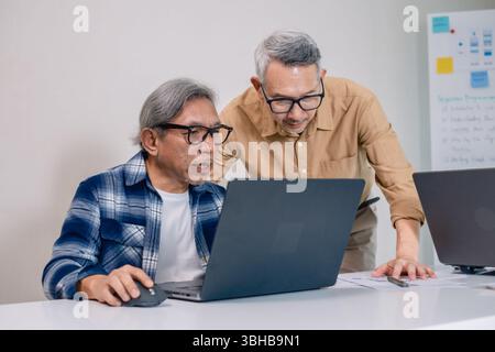 Senior male participating in a computer programming bootcamp, improving skills and learning coding and develope collaborating in brainstorming and cod Stock Photo