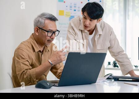 Asian senior bootcamp team asking and  learning programming with software training and whiteboard collaboration Stock Photo