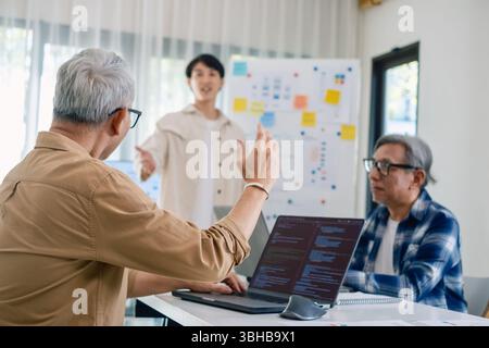 Asian senior bootcamp team asking and  learning programming with software training and whiteboard collaboration Stock Photo