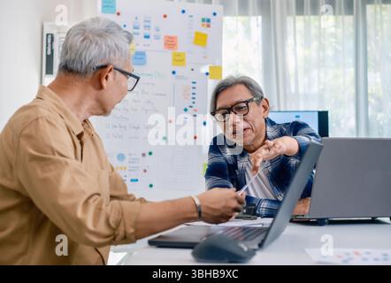 Senior male participating in a computer programming bootcamp, improving skills and learning coding and develope collaborating in brainstorming and cod Stock Photo