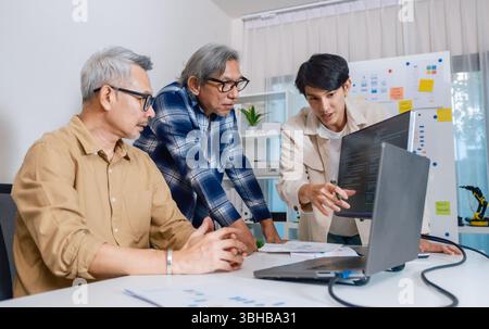 Team of developers collaborating in brainstorming and coding project at office workspace Stock Photo