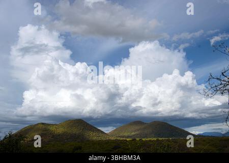 As the heat of the day builds up a large Cumulonimbus cloud develops, threatening heavy rainfall later in the day. Stock Photo