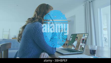 Image of biometric fingerprint scanner over caucasian woman having a imagecall on laptop at home. Cyber security and business technology concept Stock Photo