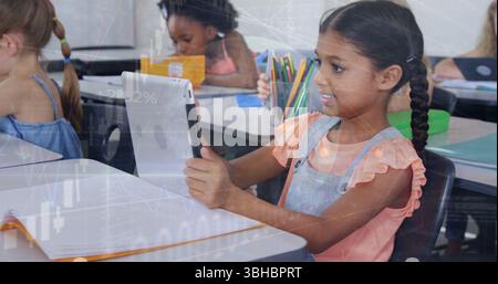 Image of multiracial girl using tablet with students in classroom over globe and graphs. Digital composite, multiple exposure, education, globalizatio Stock Photo