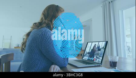 Image of biometric fingerprint scanner over caucasian having a imagecall on laptop at home. Cyber security and business technology concept Stock Photo