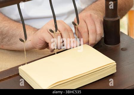 Italy, Lombardy, Reenactment Ancient Crafts, Man Hands Binding Book Stock Photo