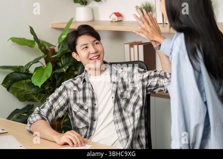 Positive UX and UI Design Interaction. Team members sharing ideas in a bright workspace. Stock Photo