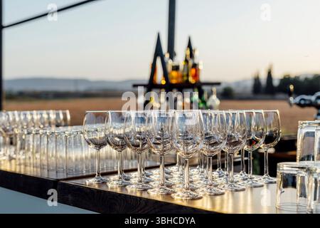 Romantically set dinner table with wine glasses and floral centerpiece, perfect for a wedding, elegant party, or outdoor evening celebration. Warm lig Stock Photo