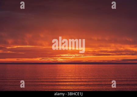 A vivid sunset over a clam ocean. Stock Photo