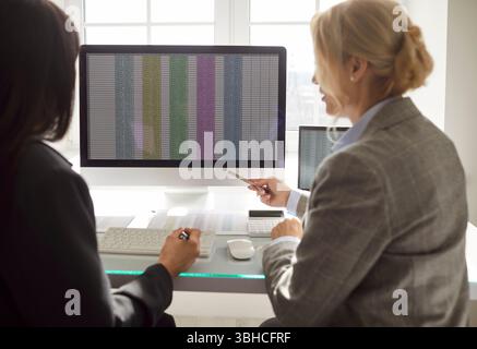 Women Coworkers Managing Accounting In Office Meeting Stock Photo