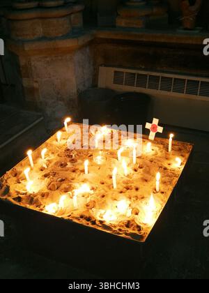 Candles Burning in Sand at a Religious Memorial Setting. Boston, UK Stock Photo