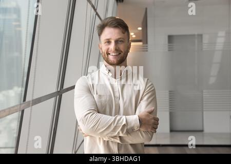 Portrait of young Caucasian man posing alone in office Stock Photo