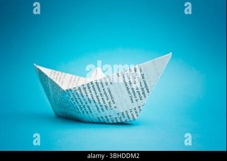 paper ship on blue background Stock Photo