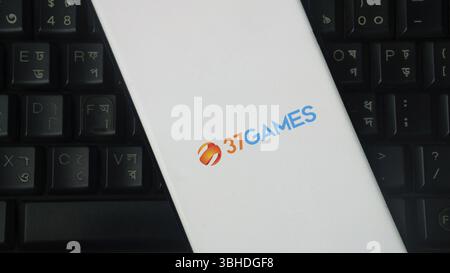Smartphone showing 37Games logo laid on a keyboard in a simple style Stock Photo