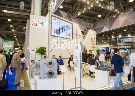 moscow, russia, 28.06.2017 A large group of people are walking around a convention hall with a large screen displaying the word FM on it Stock Photo